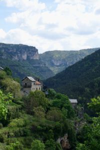 Steinhäuser im üppigen Grün, mit sanften Hügeln unter einem wolkigen Himmel – ideal für geführte Motorradtouren.