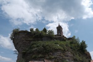 Ein hoher Turm auf einem felsigen Hügel bietet eine atemberaubende Aussicht für diejenigen, die geführte Motorradtouren in der Natur unternehmen.