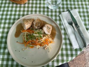 Saftiges Hühnchen auf Nudeln, beträufelt mit brauner Soße und Gemüse, weckt Erinnerungen an ein kulinarisches Abenteuer.