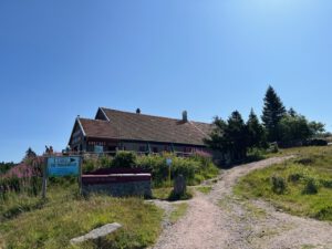 Eine gemütliche Berghütte mit Schrägdach mitten im Grünen ist ein ruhiger Rückzugsort für geführte Motorradtouren.