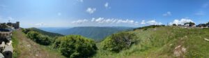 Genießen Sie geführte Motorradtouren durch ein üppiges Tal mit sanften Hügeln, klarem Himmel und malerischer Aussicht.