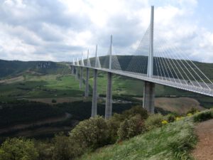 Das Viadukt von Millau in Frankreich überspannt ein üppiges Tal und eignet sich ideal für geführte Motorradtouren unter seinen hoch aufragenden Bögen.
