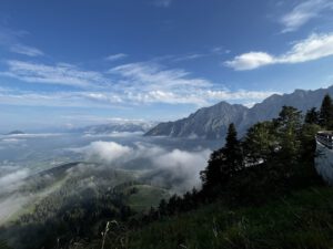 Majestätische Berge und üppiges Grün, ideal für geführte Motorradtouren unter teilweise bewölktem Himmel.