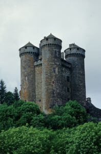Entdecken Sie eine mittelalterliche Steinburg mit vier hohen Türmen, die sich perfekt für die Erkundung auf geführten Motorradreisen eignet.