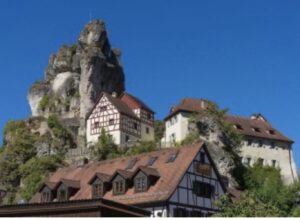 Charmante Fachwerkhäuser auf Felsen verschmelzen nahtlos mit dem klaren blauen Himmel.